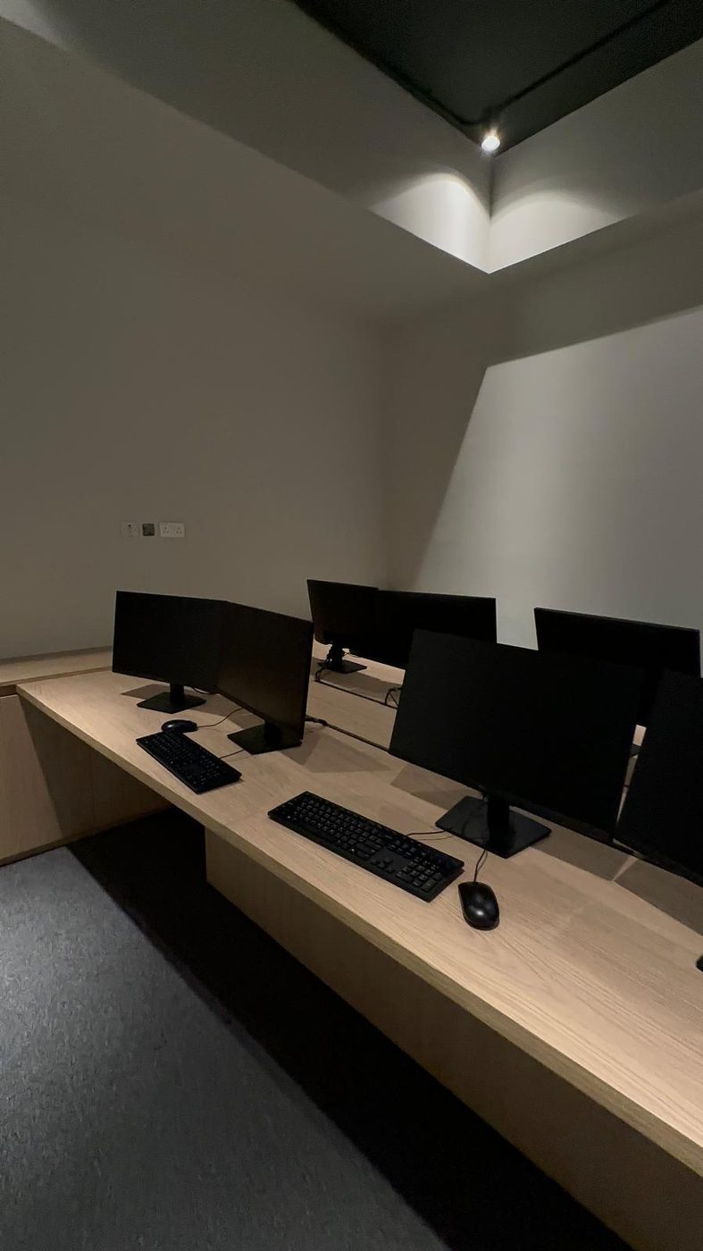 Long built-in oak desk running the length of an office room with multiple monitor stations