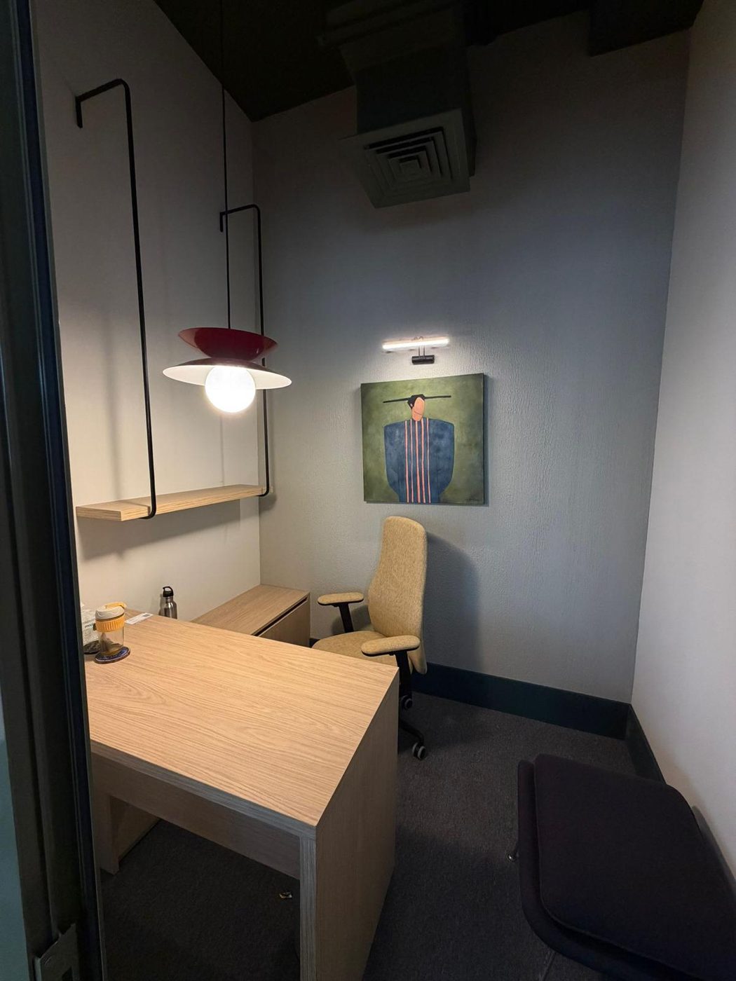Private office with a custom oak desk and return, floating shelf and pendant light